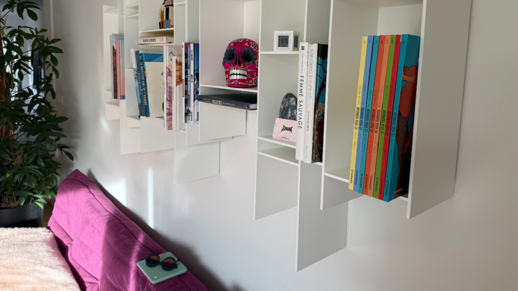 Déco qui me ressemble avec canapé violet, étagères murales et objets personnels