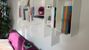 Déco qui me ressemble avec canapé violet, étagères murales et objets personnels